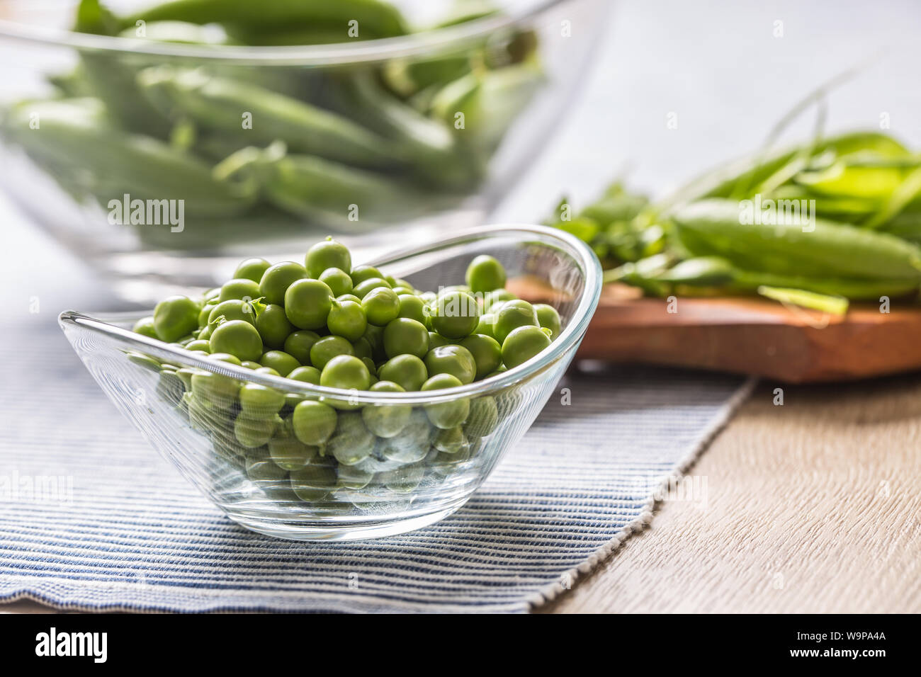 Fresco verde i semi di pisello nella ciotola sul tavolo da cucina Foto Stock