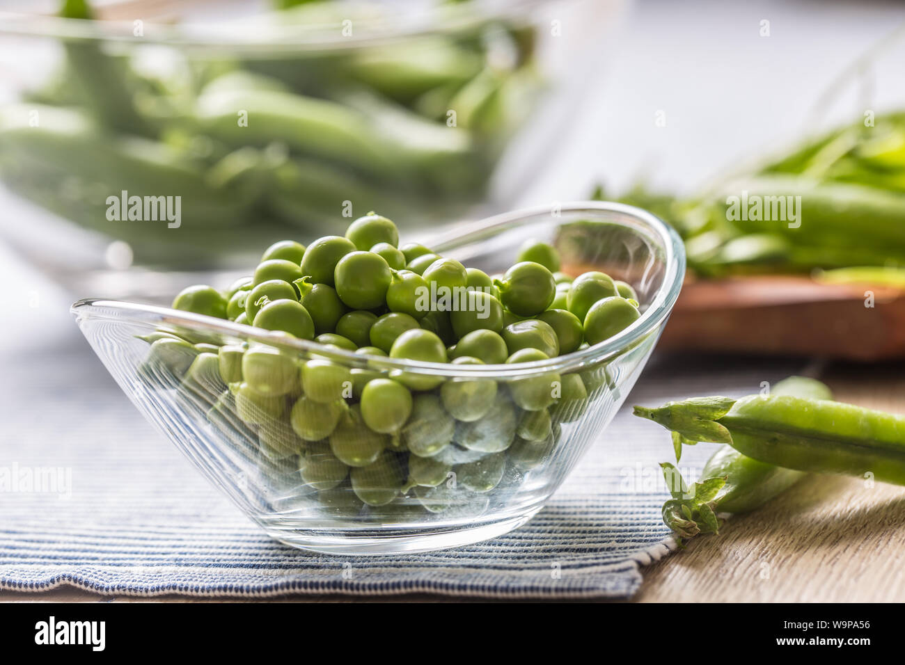 Fresco verde i semi di pisello nella ciotola sul tavolo da cucina Foto Stock