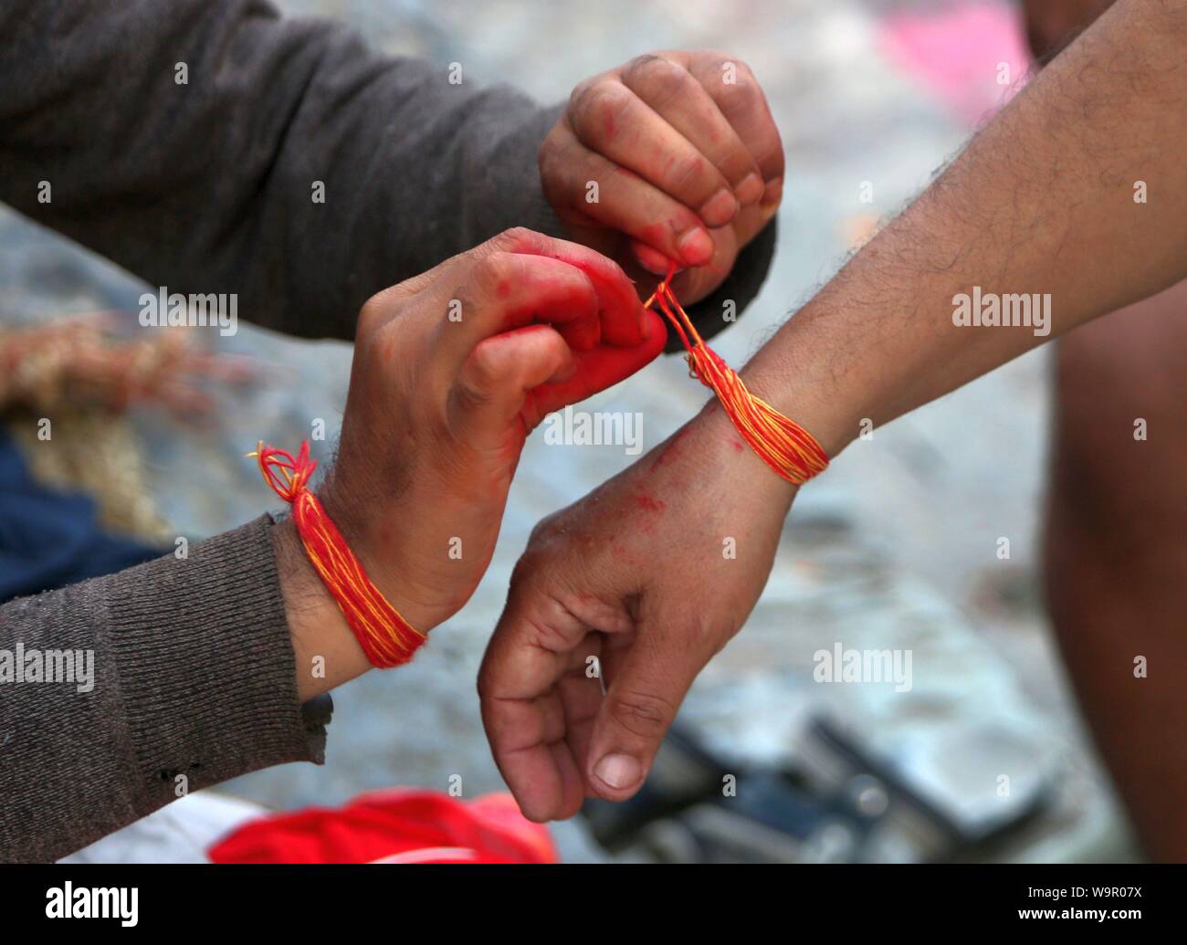 Kathmandu, Nepal. Il 15 agosto, 2019. Un sacerdote esegue i rituali religiosi di un uomo durante la Janai Purnima festival presso il Tempio di Pashupatinath a Kathmandu, Nepal, il 15 agosto 2019. Durante questo festival, Indù prendere bagno santo e di eseguire la variazione annua del Janai, un sacro corde di cotone indossato intorno al loro petto o legato al polso, nella convinzione che essa sia in grado di proteggere e purificarli. Credito: Sunil Sharma/Xinhua Foto Stock