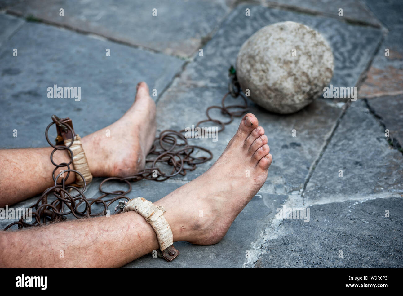 Prisioner con la palla e la catena nel cortile della prigione. Close up. Concetto di trattamenti disumani e degradanti condizioni di detenzione. Foto Stock