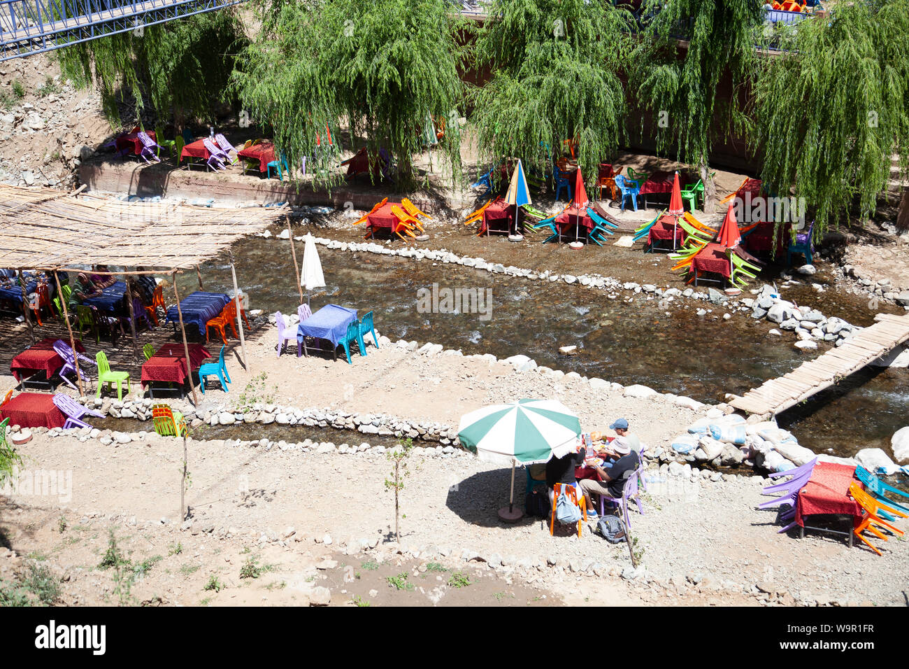 Persone sedersi presso i ristoranti sul fiume di Sti Fadma, Ourika Valley in Atlas Mountains, Marocco Foto Stock
