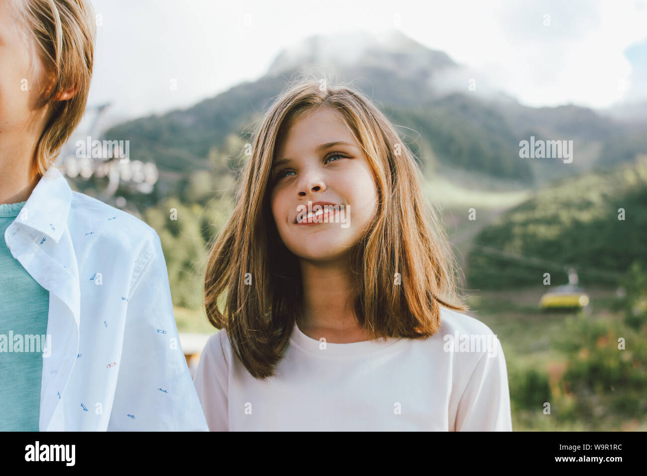 I bambini del fratello e sorella amici guarda con ammirazione sullo sfondo del resort di montagna, viaggi in famiglia Foto Stock