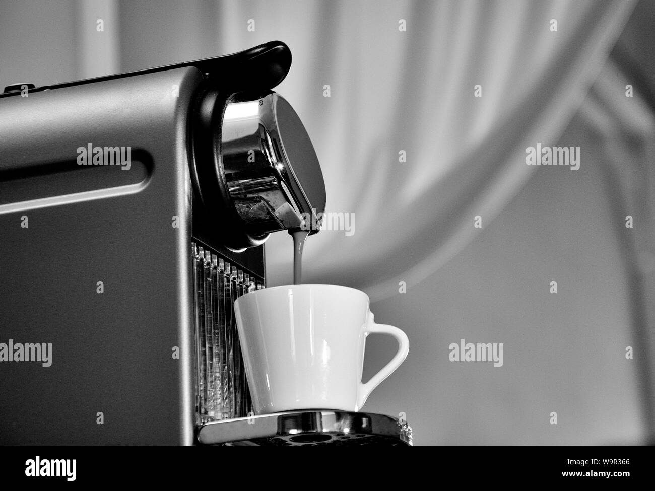 Macchina espresso in azione, il riempimento di una buona tazza di caffè. Foto Stock