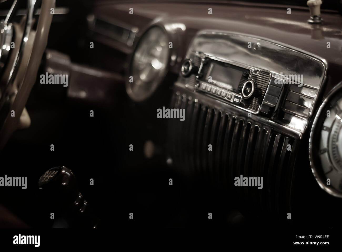 Sfondo sfocato stilizzata come vecchie foto in bianco e nero- un frammento dell'interno di un'auto d'epoca, focus sulla maniglia della radio Foto Stock