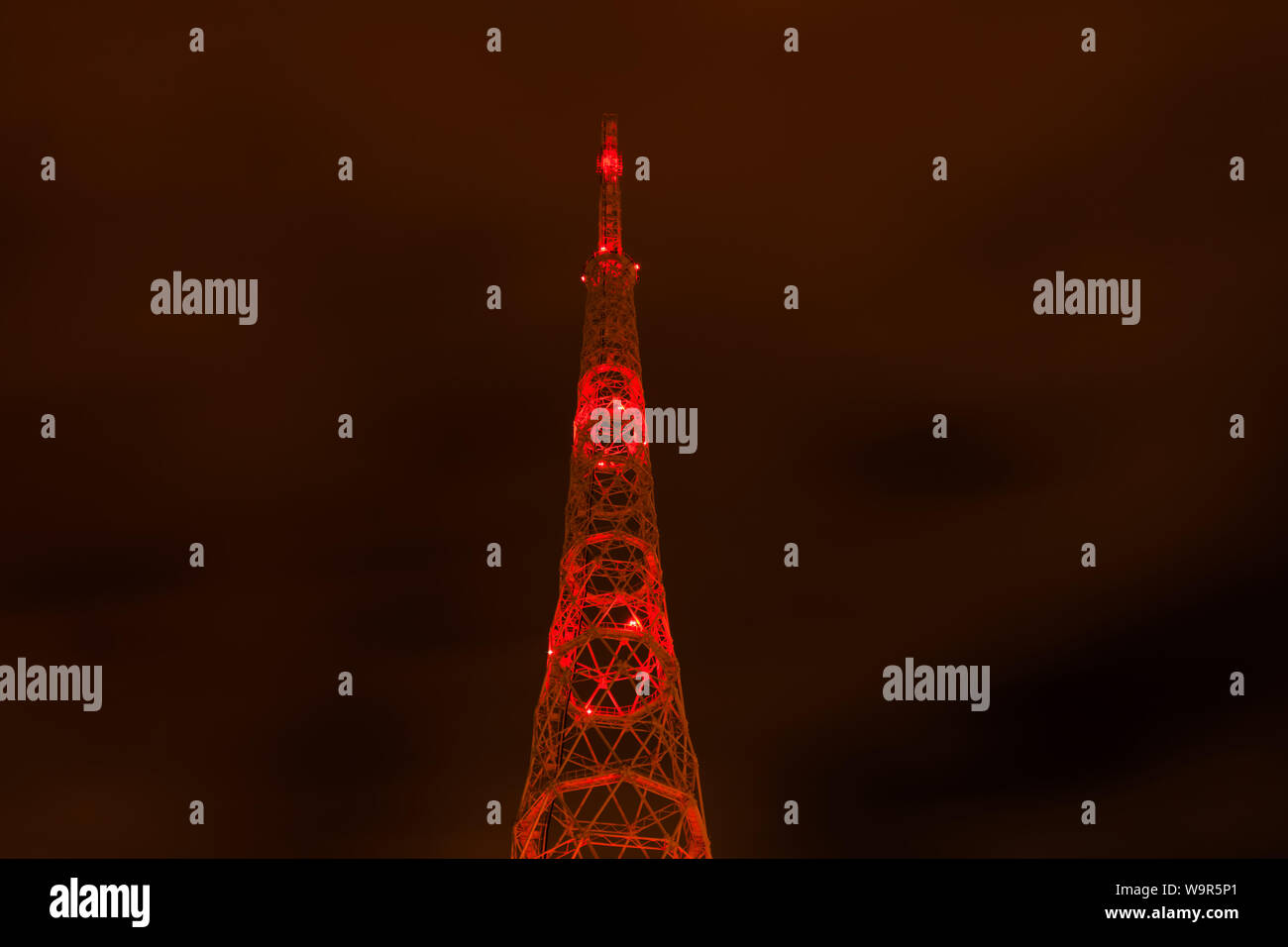 Vista notturna della torre della TV con aeromobili rosso spie sotto il cielo viola Foto Stock