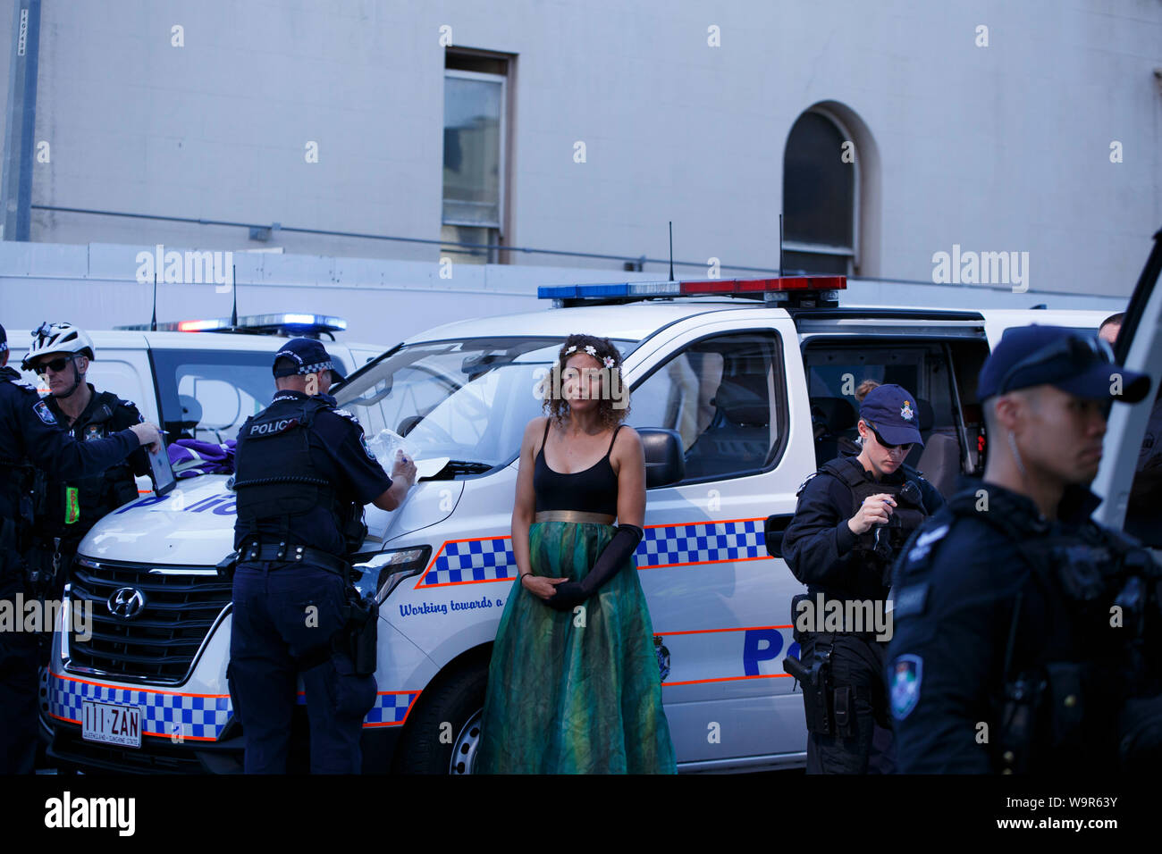 Una donna durante il suo arresto per interruzione del traffico durante la ribellione di estinzione protestare in Brisbane Central Business District. Foto Stock