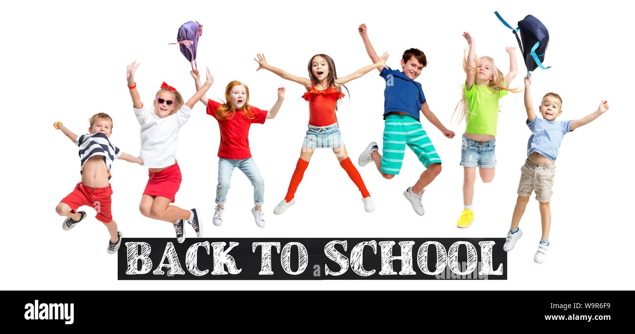Gruppo di scuola elementare i bambini o gli studenti jumping in colorate abiti casual jumping isolato su bianco di sfondo per studio. Collage creativi. Si torna a scuola, l'istruzione, il concetto di infanzia. Foto Stock