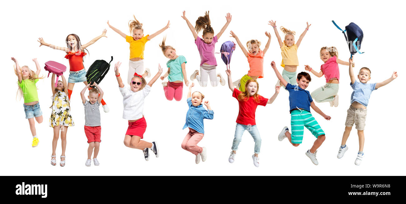 Gruppo di scuola elementare i bambini o gli studenti jumping in colorate abiti casual jumping isolato su bianco di sfondo per studio. Collage creativi. Si torna a scuola, l'istruzione, il concetto di infanzia. Foto Stock