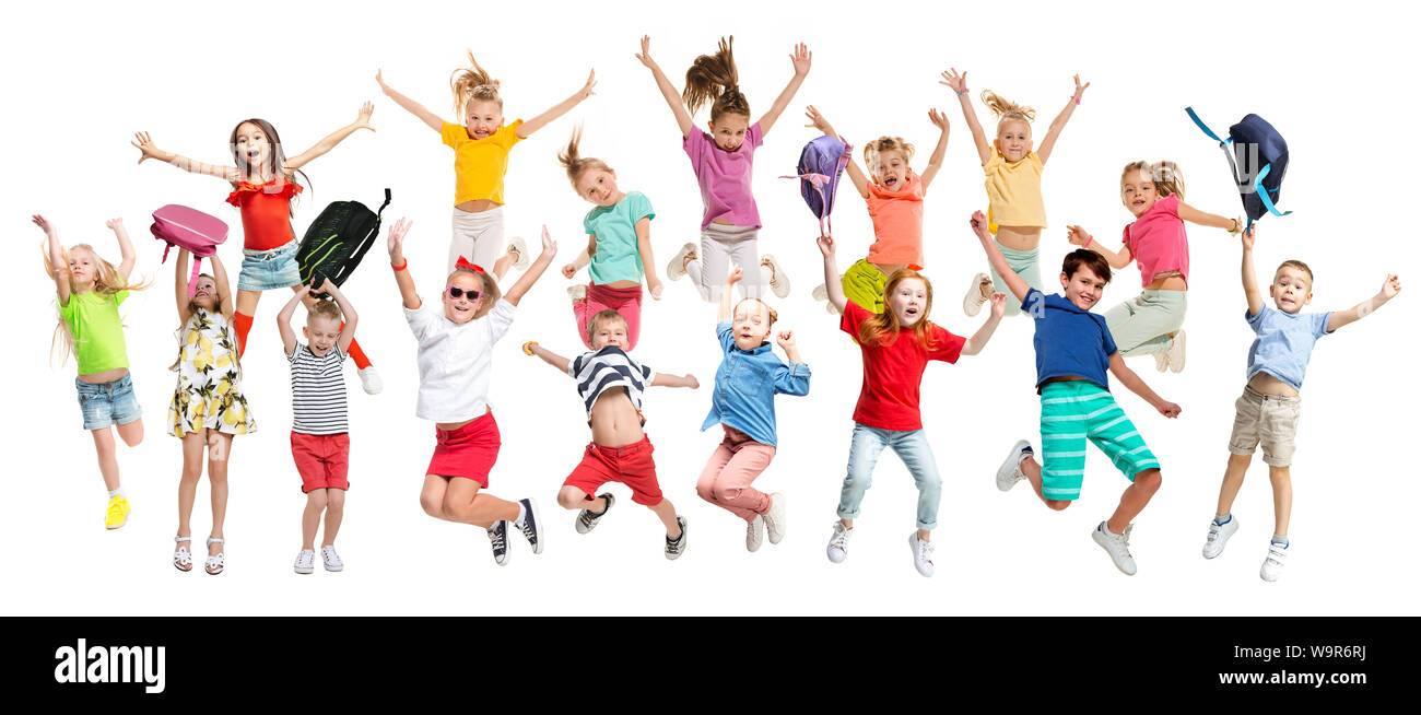 Gruppo di scuola elementare i bambini o gli studenti jumping in colorate abiti casual jumping isolato su bianco di sfondo per studio. Collage creativi. Si torna a scuola, l'istruzione, il concetto di infanzia. Foto Stock