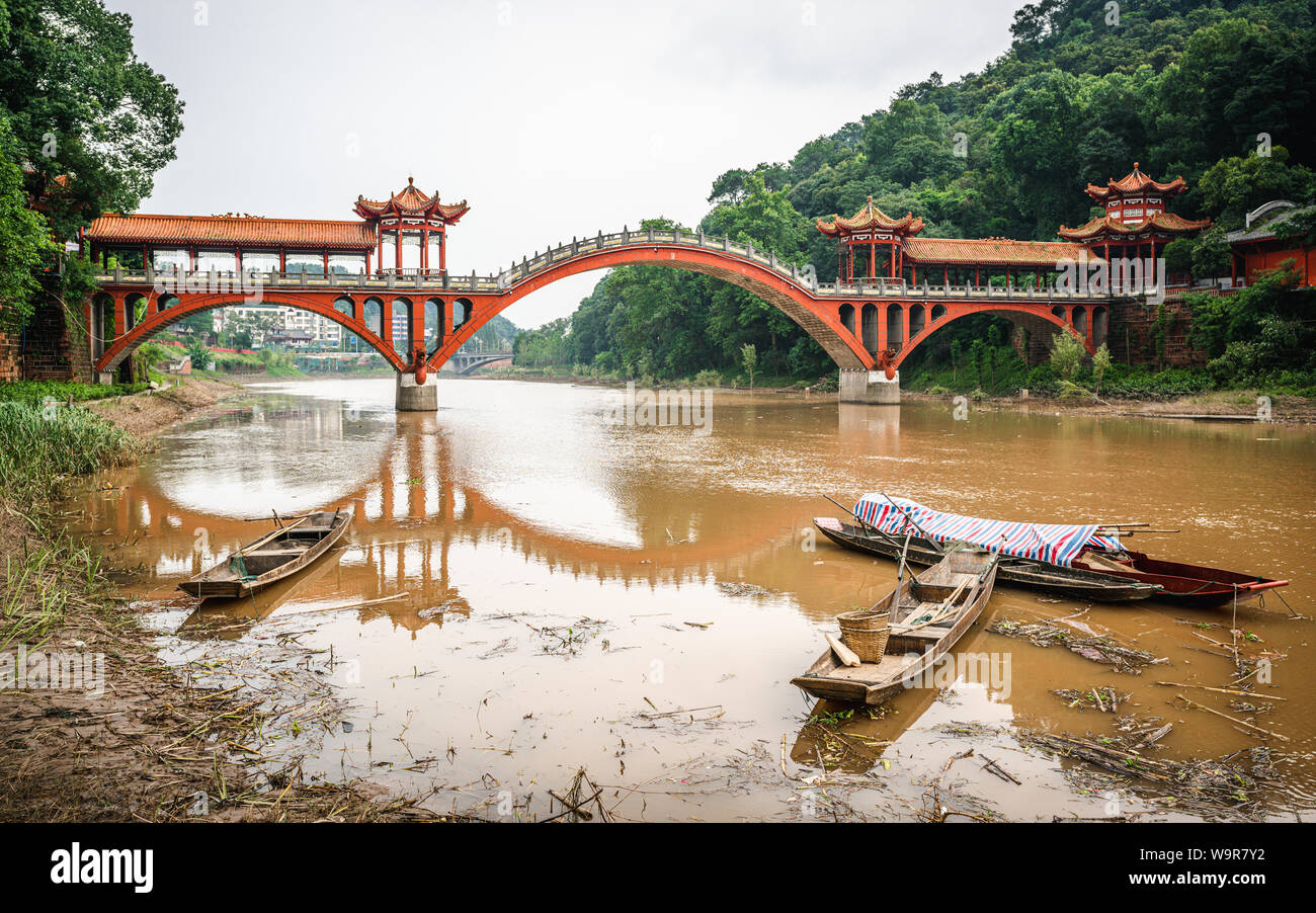 Haoshang ponte di arco in oriental Buddha park e piccole barche da pesca sul fiume di Leshan Sichuan in Cina Foto Stock
