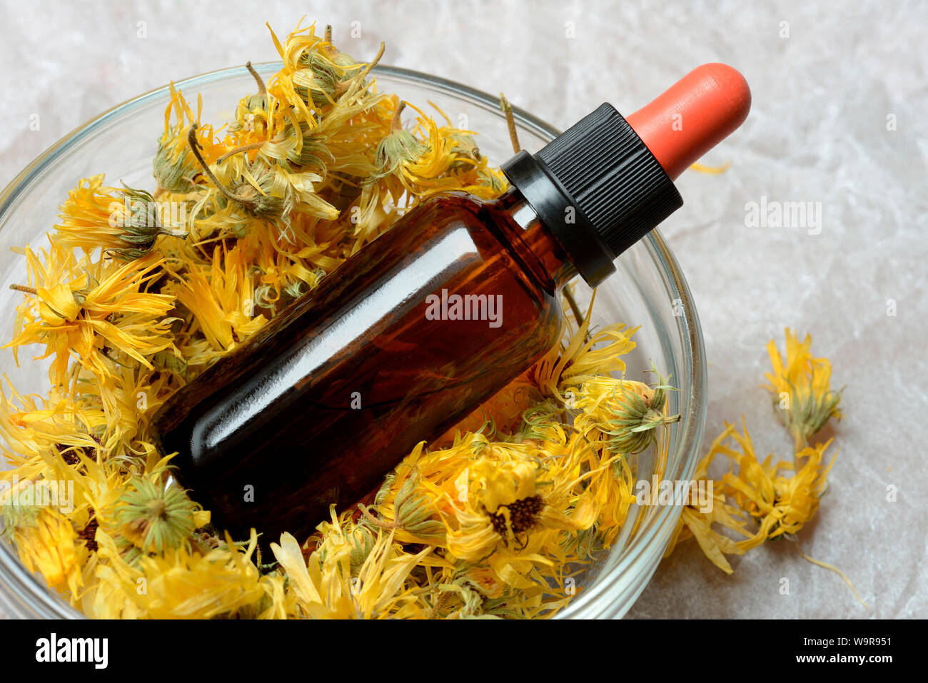 Getrocknete Ringelblumenblueten in Schale, Flaeschchen mit Ringelblumentinktur, Calendula officinalis Foto Stock