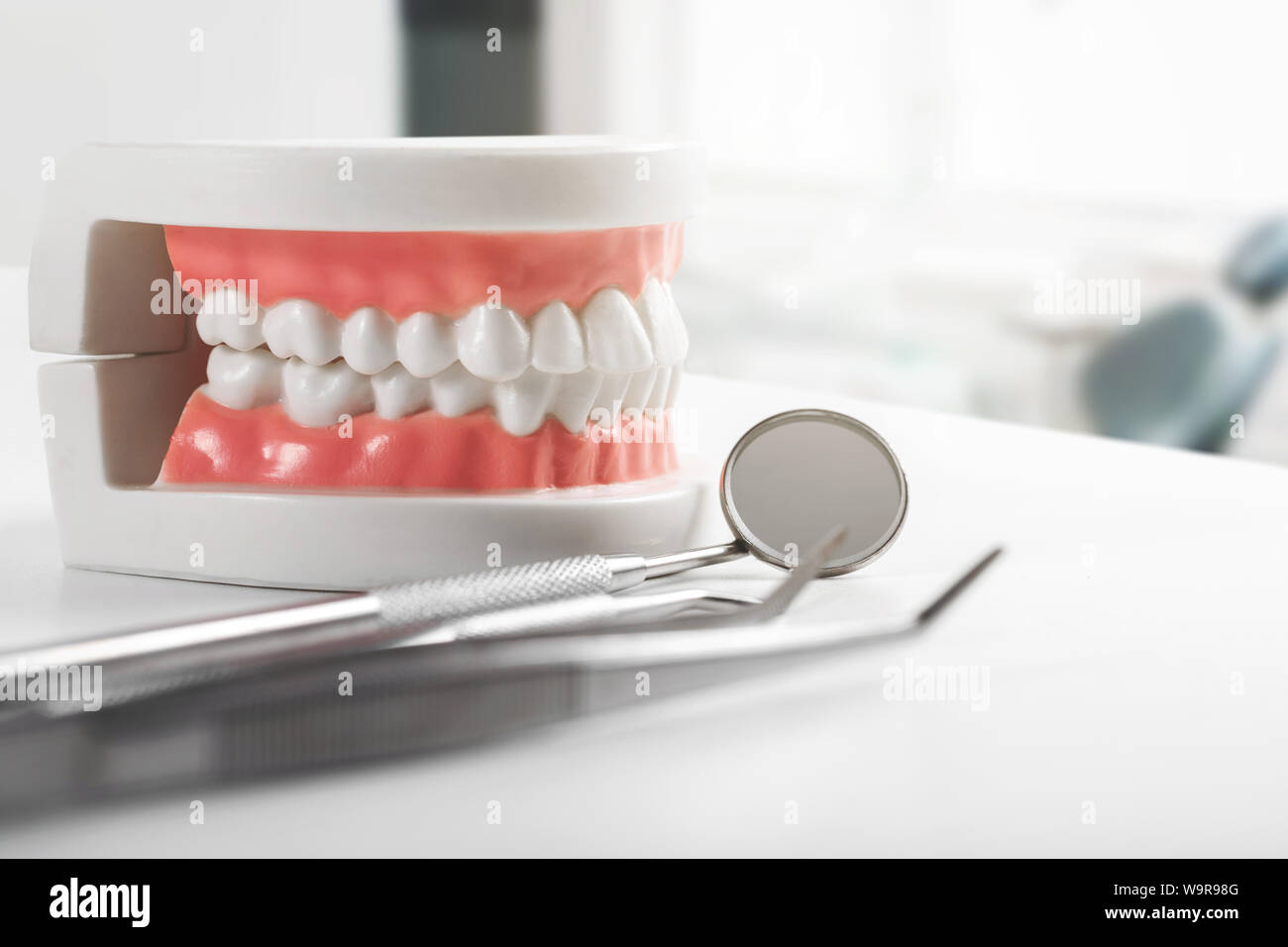 Modello di denti e strumenti dentali sulla tavola in studio dentistico Foto Stock