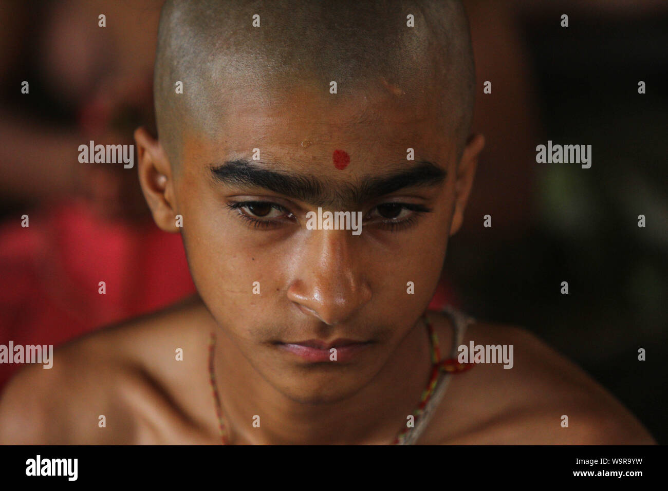 Kathmandu, Nepal. Il 15 agosto, 2019. Un giovane sacerdote Indù si affaccia su durante il festival. Il Janai Purnima Festival è anche noto come il filetto sacred festa durante la quale gli uomini indù, specialmente il Brahmans e Chettris, eseguire la loro annuale modifica di Janai, un giallo cotone stringa indossato sul torace o legato attorno al polso per la protezione e la purificazione. Credito: SOPA Immagini limitata/Alamy Live News Foto Stock