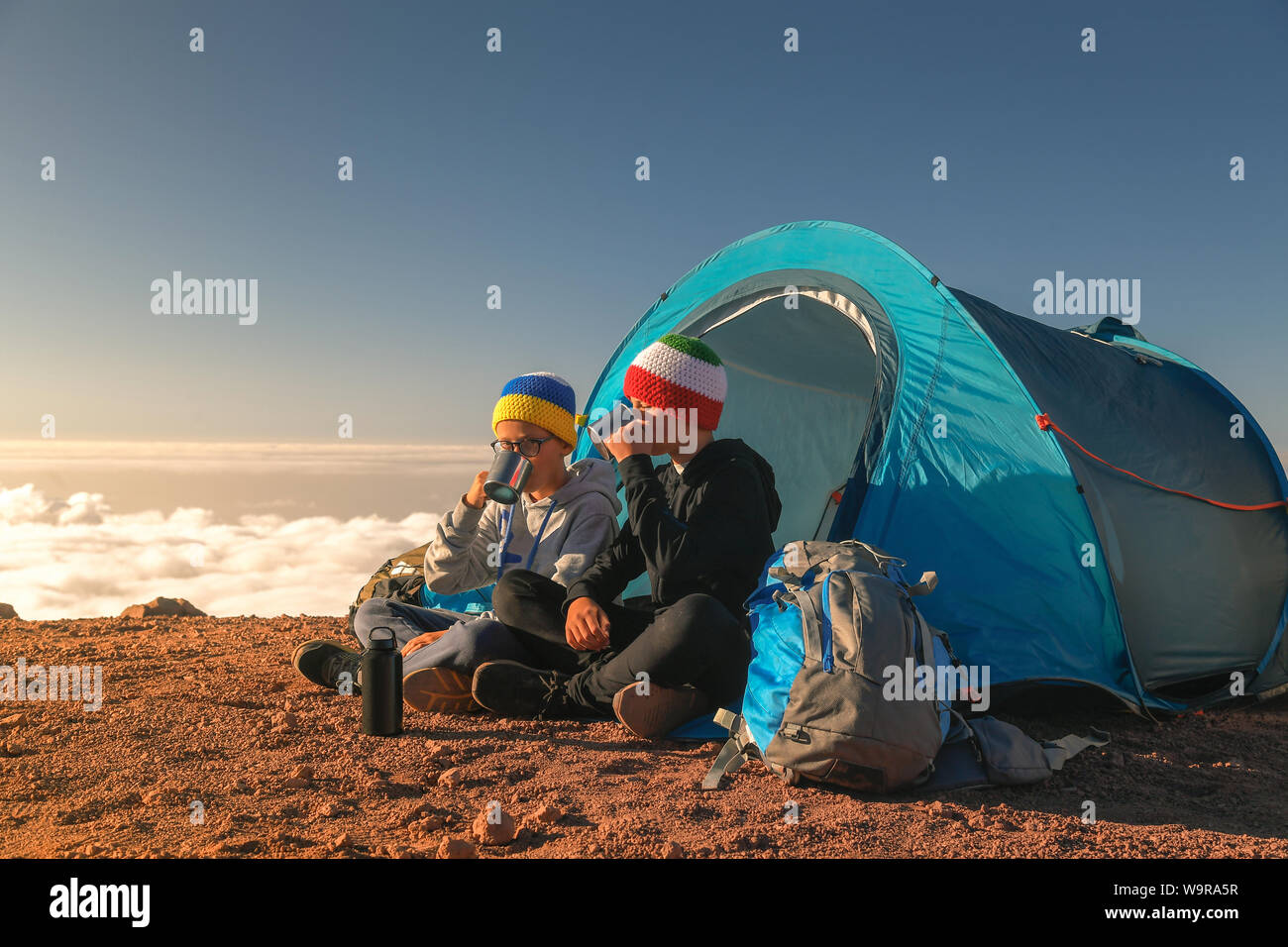 Due ragazzi tenendo selfie seduti in una tenda da campeggio Due ragazzi tenendo selfie seduti in una tenda da campeggio