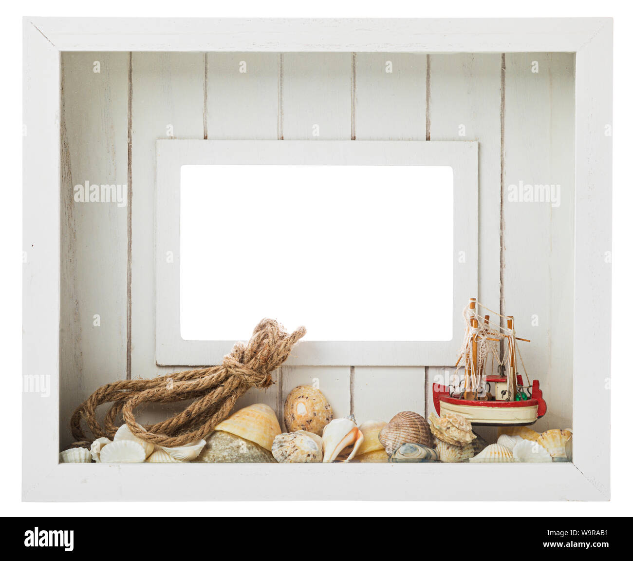 Bianco in legno picture frame con decorazione marittima come conchiglie di mare, lumache di mare, modello di barca da pesca e la corda isolato con percorso di clipping su bianco b Foto Stock