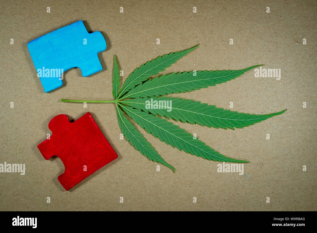Cannabis leaf e puzzle in legno pezzi di puzzle su kraft carta marrone Foto Stock
