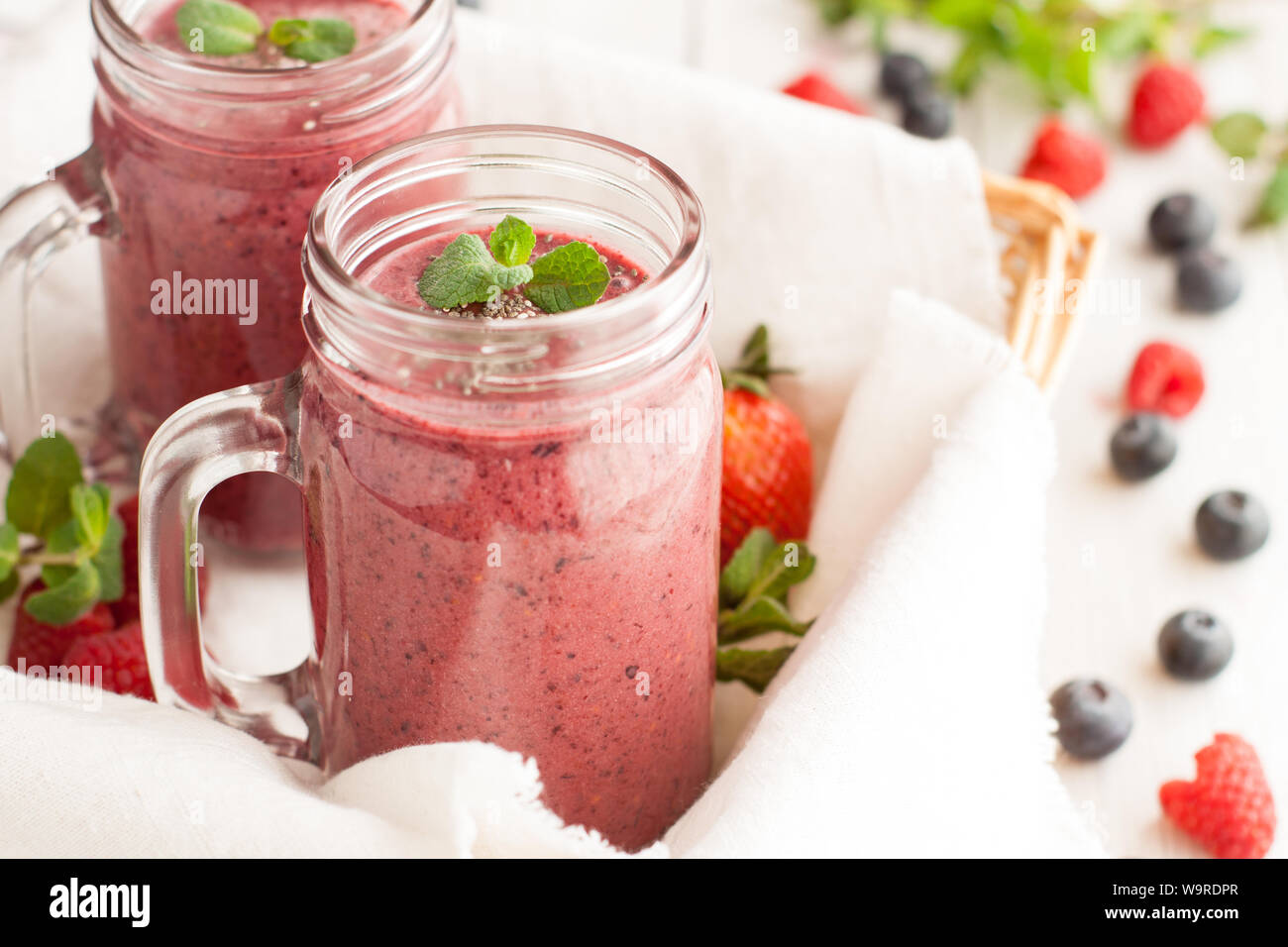 Berry mix potein cioccolato frullati in Mason jar su sfondo chiaro Foto Stock