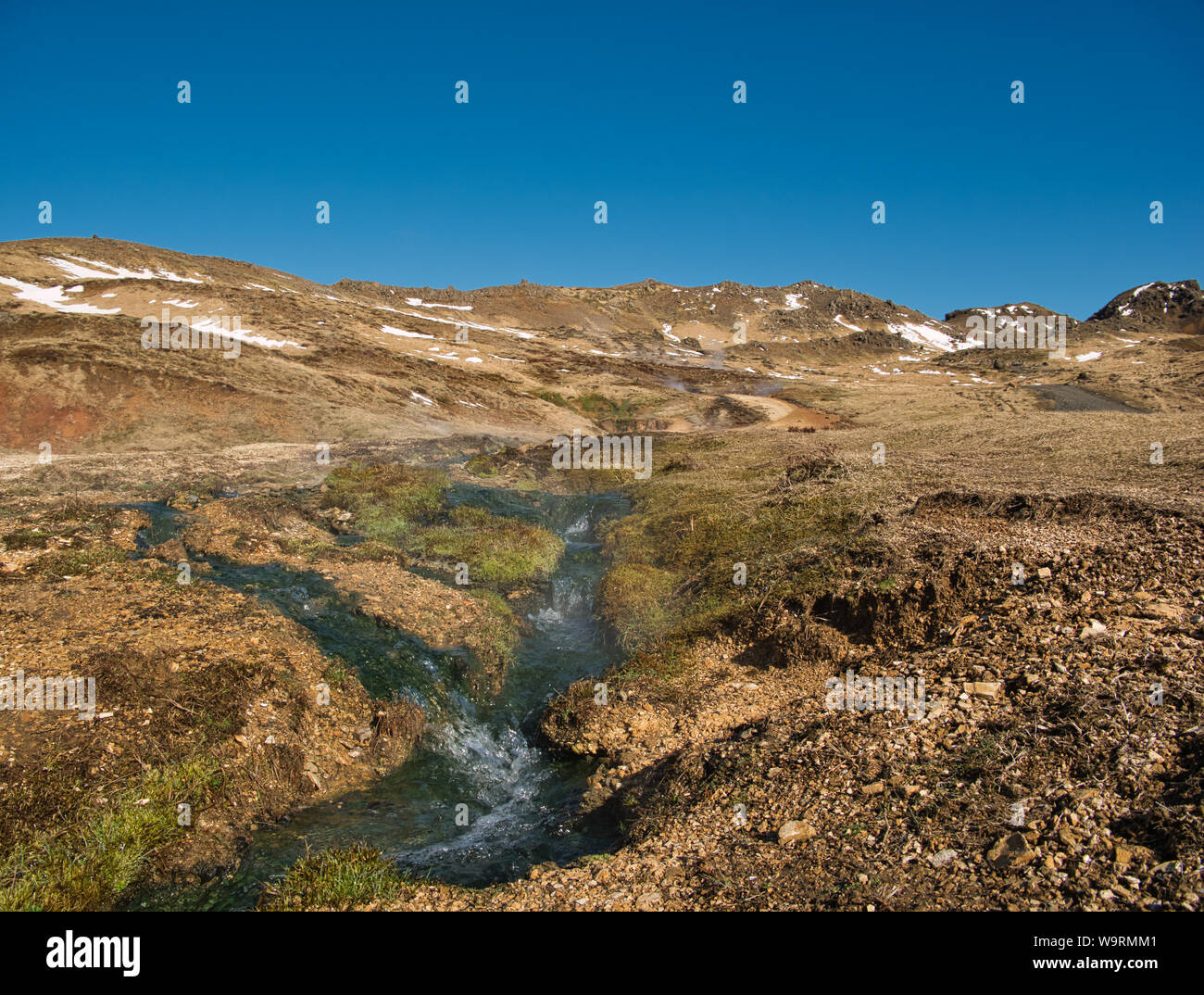 Un flusso di acqua calda termale in montagna. Foto da aprile in Islanda Foto Stock