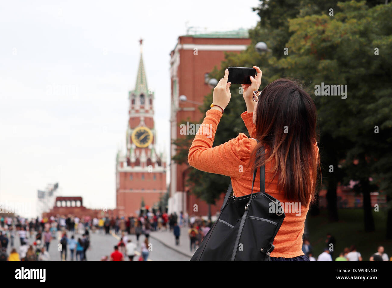 Donna turistica prendendo le foto di Moscow Kremlin sullo smartphone in estate. La folla di turisti sulla Piazza Rossa, viaggi in Russia Foto Stock