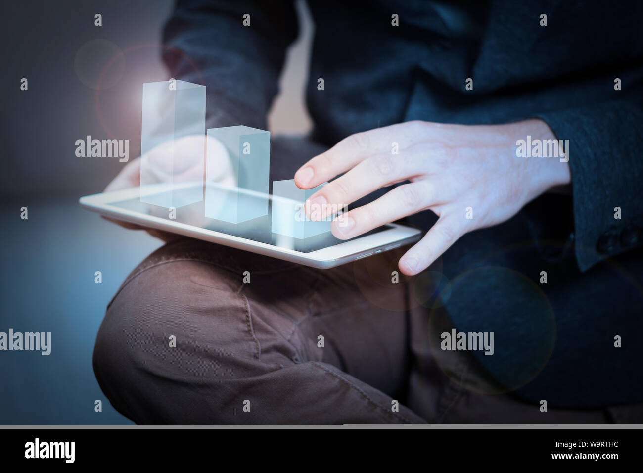 Imprenditore interagisce con ologramma grafico su un tablet Foto Stock