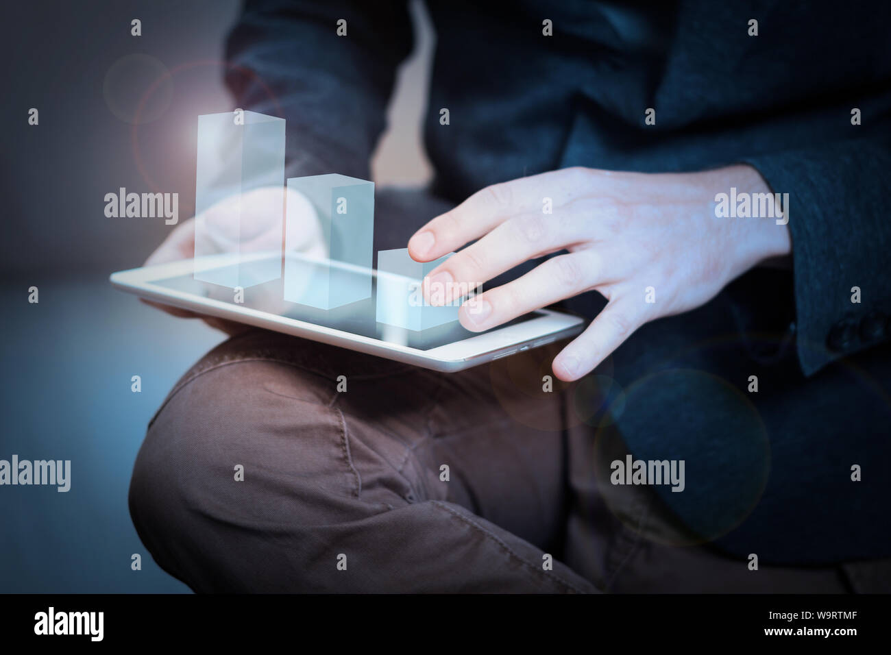 Imprenditore interagisce con ologramma grafico su un tablet Foto Stock