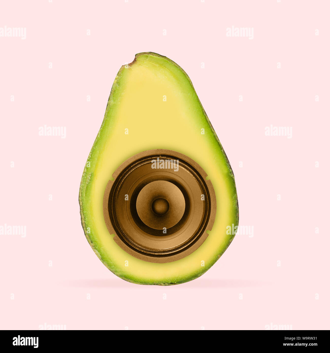 Succosa suono delle canzoni preferite. Avocado con altoparlante al suo interno su sfondo di corallo. Lo spazio negativo per inserire il tuo testo. Il design moderno. L'arte contemporanea collage. Concetto di musica. Nuovo look per il festival. Foto Stock
