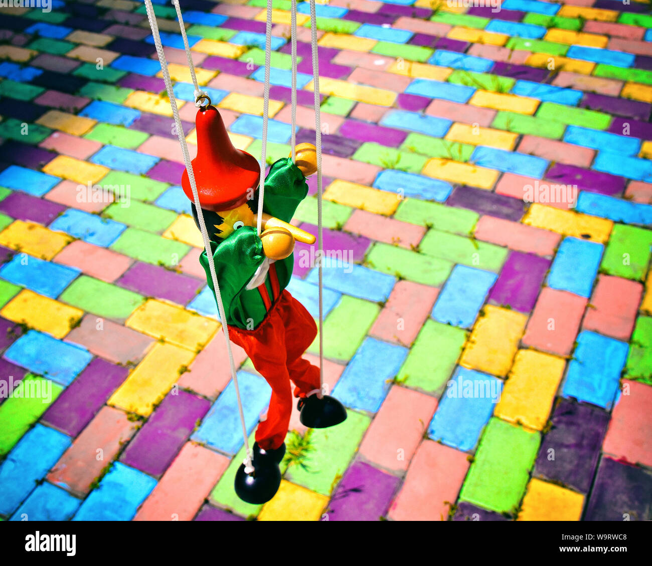 Legno vecchio Pinocchio burattino su piastrelle colorate. Le marionette giocattolo retrò. Foto Stock