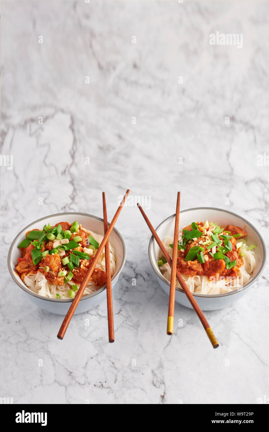 Shan tagliatelle con bacchette in marmo bianco del piano portapaziente. cucina birmana piatto tradizionale. myanmar cibo. spaghetti di riso con carne di maiale in pomodori. piatto asiatico Foto Stock