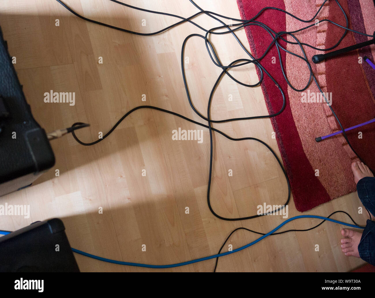 I fili di chitarra e amplificatori su un pavimento durante una prova di banda. Foto Stock