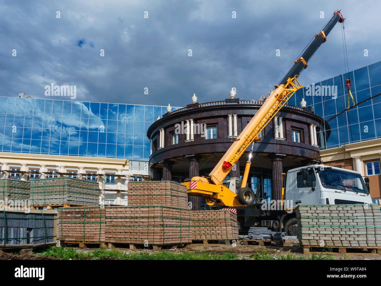Camion-gru montata su un edificio sito in costruzione Foto Stock