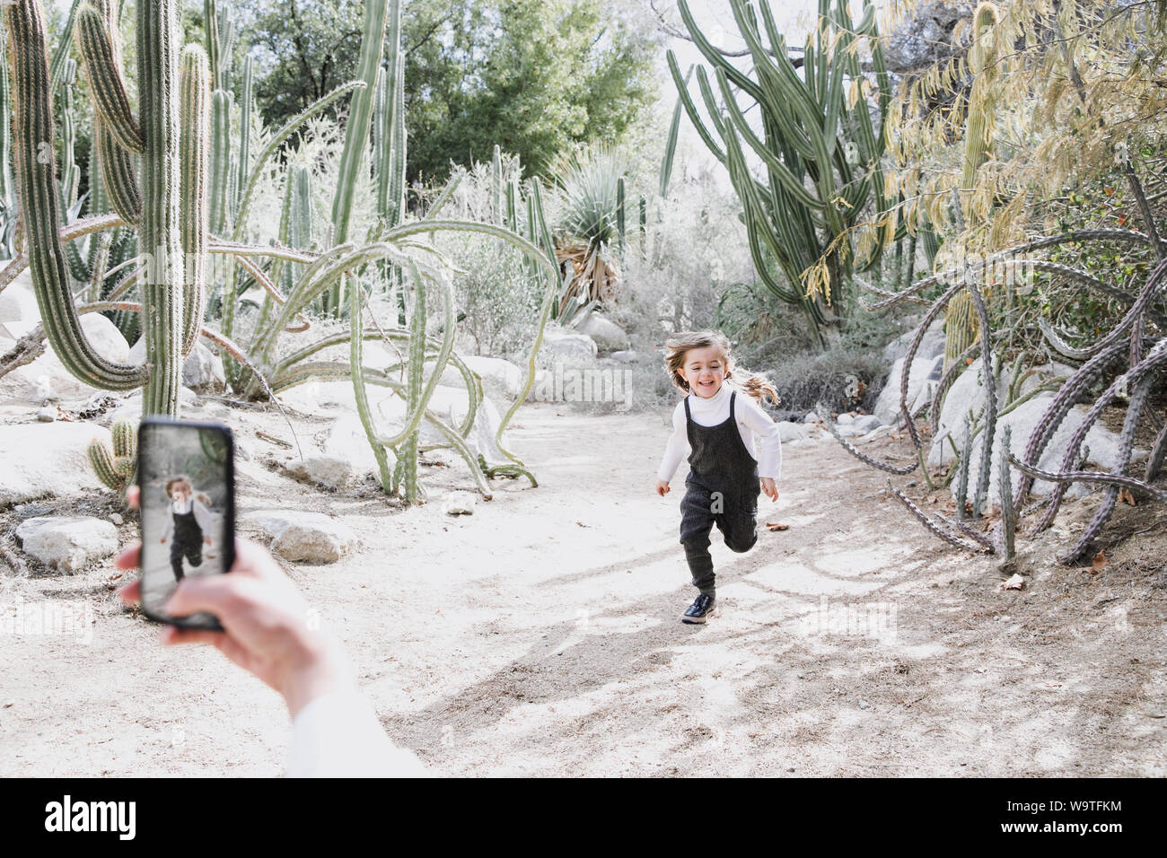 Madre di fotografare la figlia in esecuzione nel deserto, Palm Springs, California, Stati Uniti Foto Stock