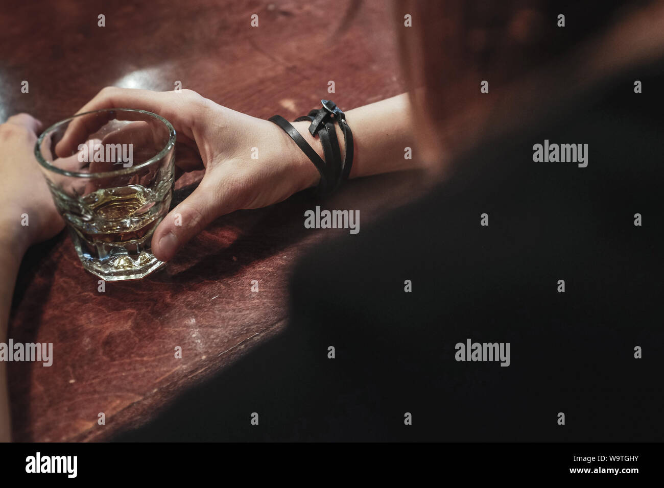 Donna bere un colpo di whisky in un bar Foto Stock