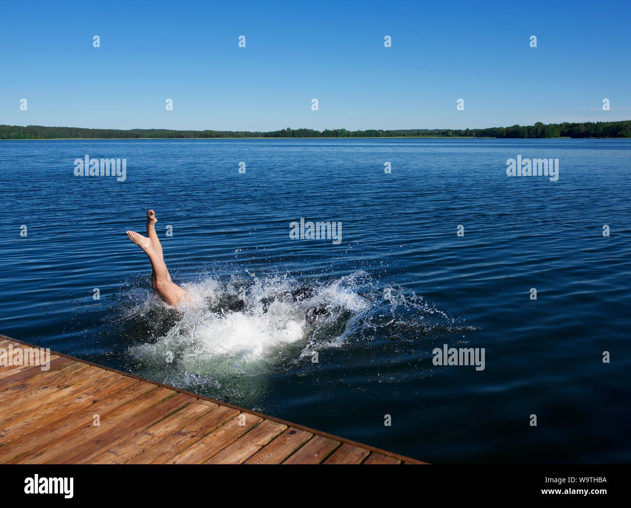 Donna tuffarsi in mare da un pontile in legno, Lituania Foto Stock