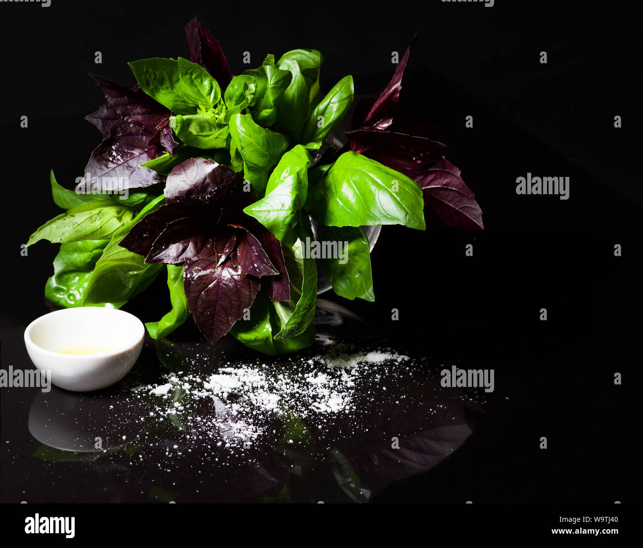 Il viola e il verde del basilico con olio di oliva e sale Foto Stock