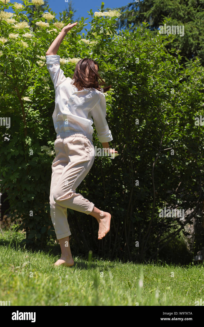 Donna felice messing about in giardino Foto Stock