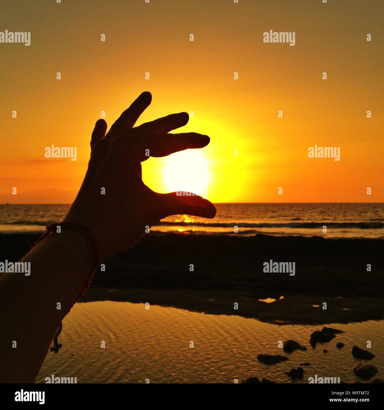 Silhouette di una mano umana tenendo premuto il sole, Spagna Foto Stock