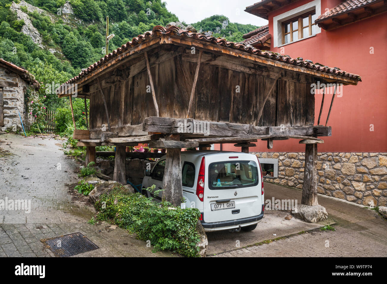Macchina parcheggiata sotto un horreo, sollevata tradizionale granaio, nel villaggio di San Juan de Beleno, ponga parco naturale, Asturias, Spagna Foto Stock