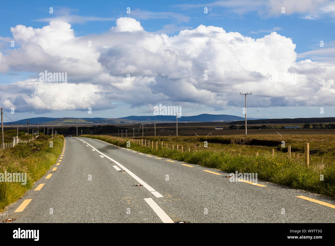 Guardando verso il basso lungo strada asfaltata nelle zone rurali del nord-ovest Irlanda Foto Stock