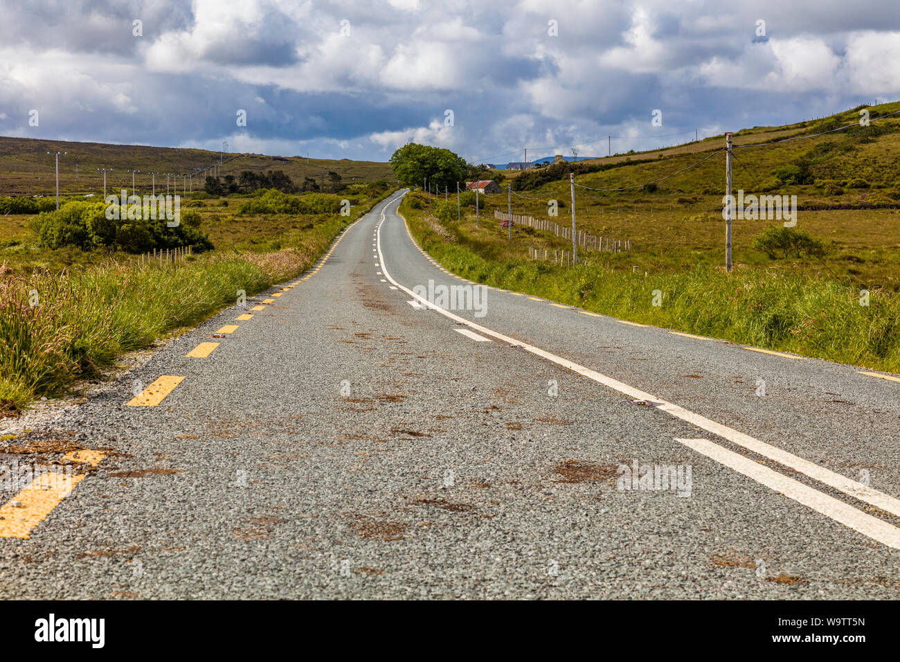 Guardando verso il basso lungo strada asfaltata nelle zone rurali del nord-ovest Irlanda Foto Stock
