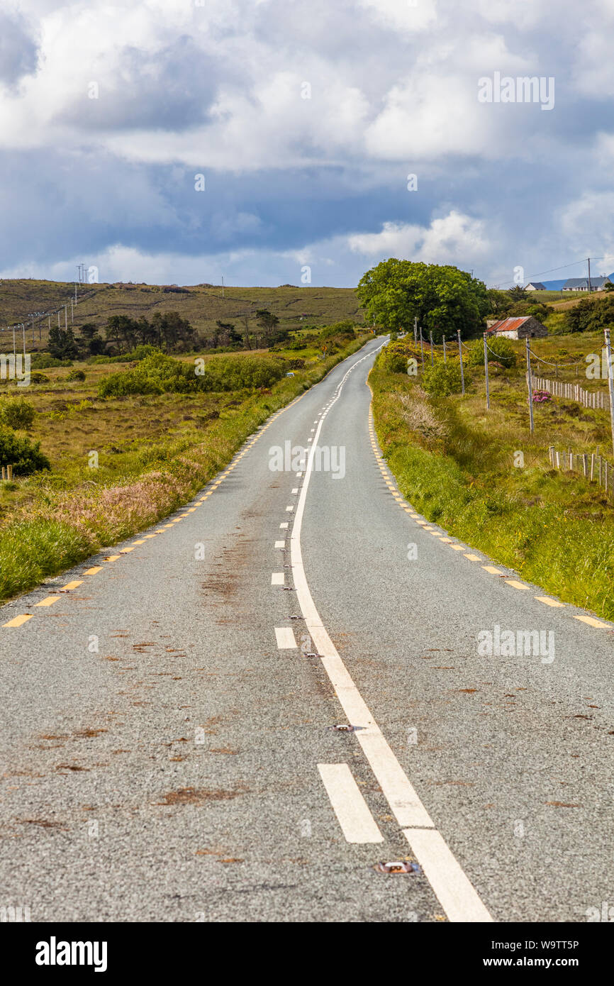Guardando verso il basso lungo strada asfaltata nelle zone rurali del nord-ovest Irlanda Foto Stock