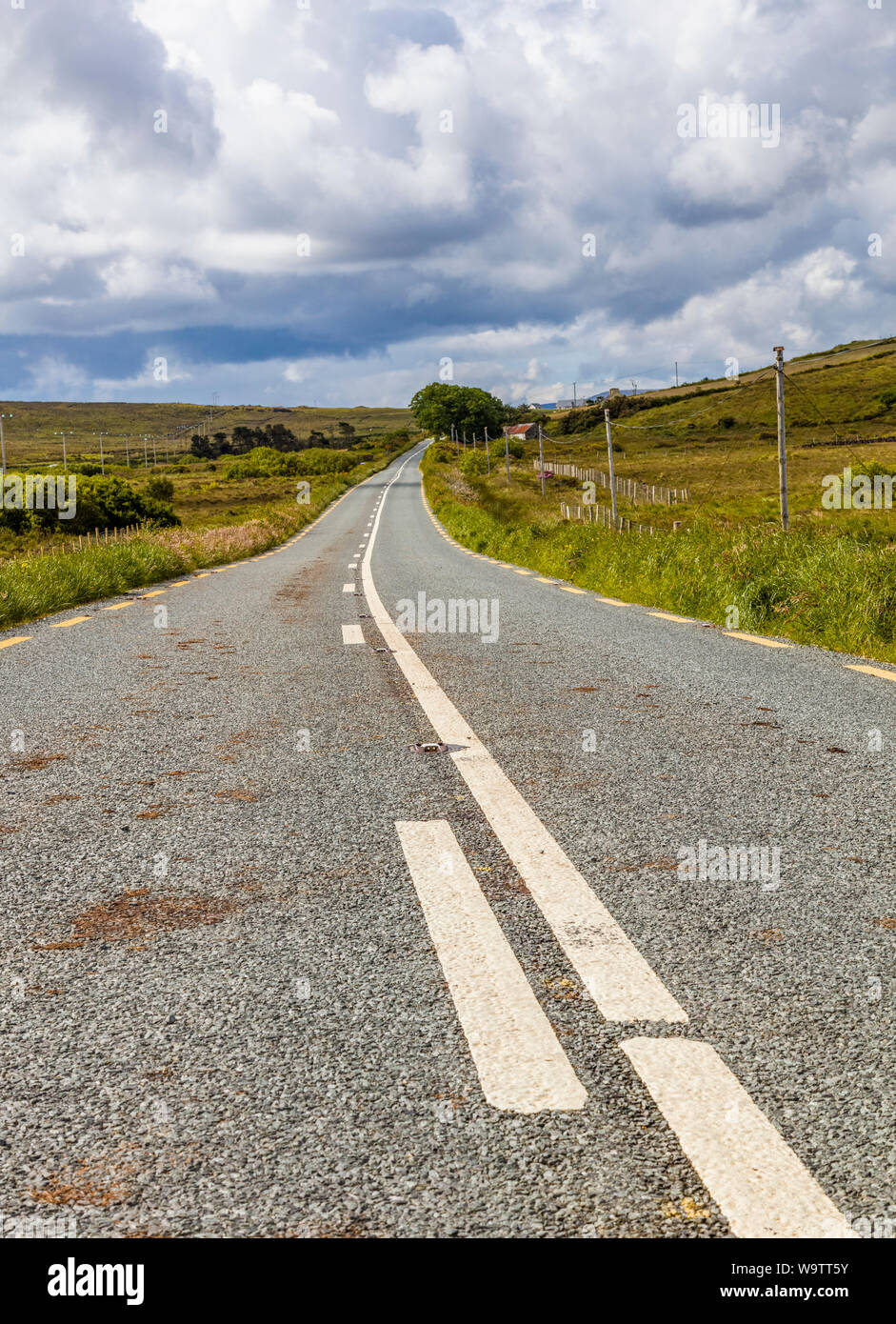 Guardando verso il basso lungo strada asfaltata nelle zone rurali del nord-ovest Irlanda Foto Stock