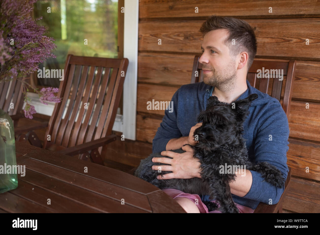 Bello caucasain Uomo con cane seduti all'aperto Foto Stock