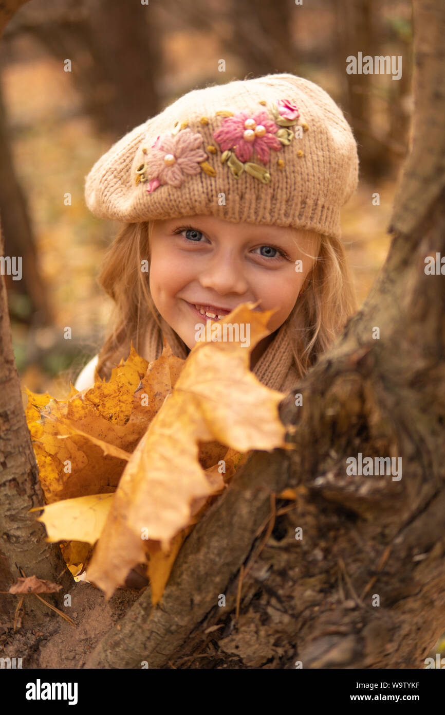 Ragazza nel Bosco in autunno tappo marrone con buon umore e dagli occhi brillanti e di foglia Foto Stock