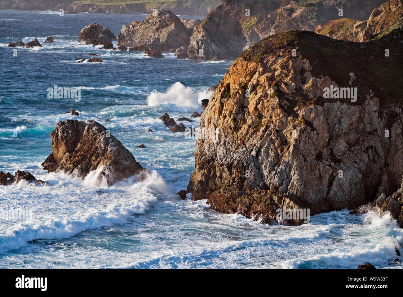 Ultima luce sulle onde che si infrangono contro il mare di pile e il litorale a Garrapata State Park California lungo la costa di Monterey. Foto Stock