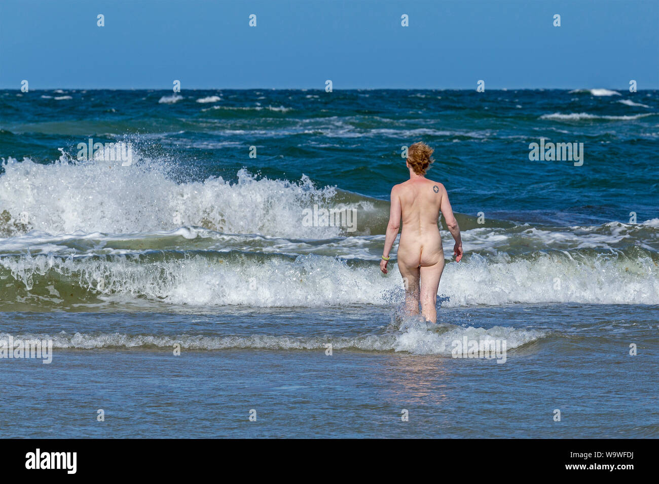 Donna skinny-immersione, vento onde, spiaggia di Wustrow, Meclemburgo-Pomerania Occidentale, Germania Foto Stock