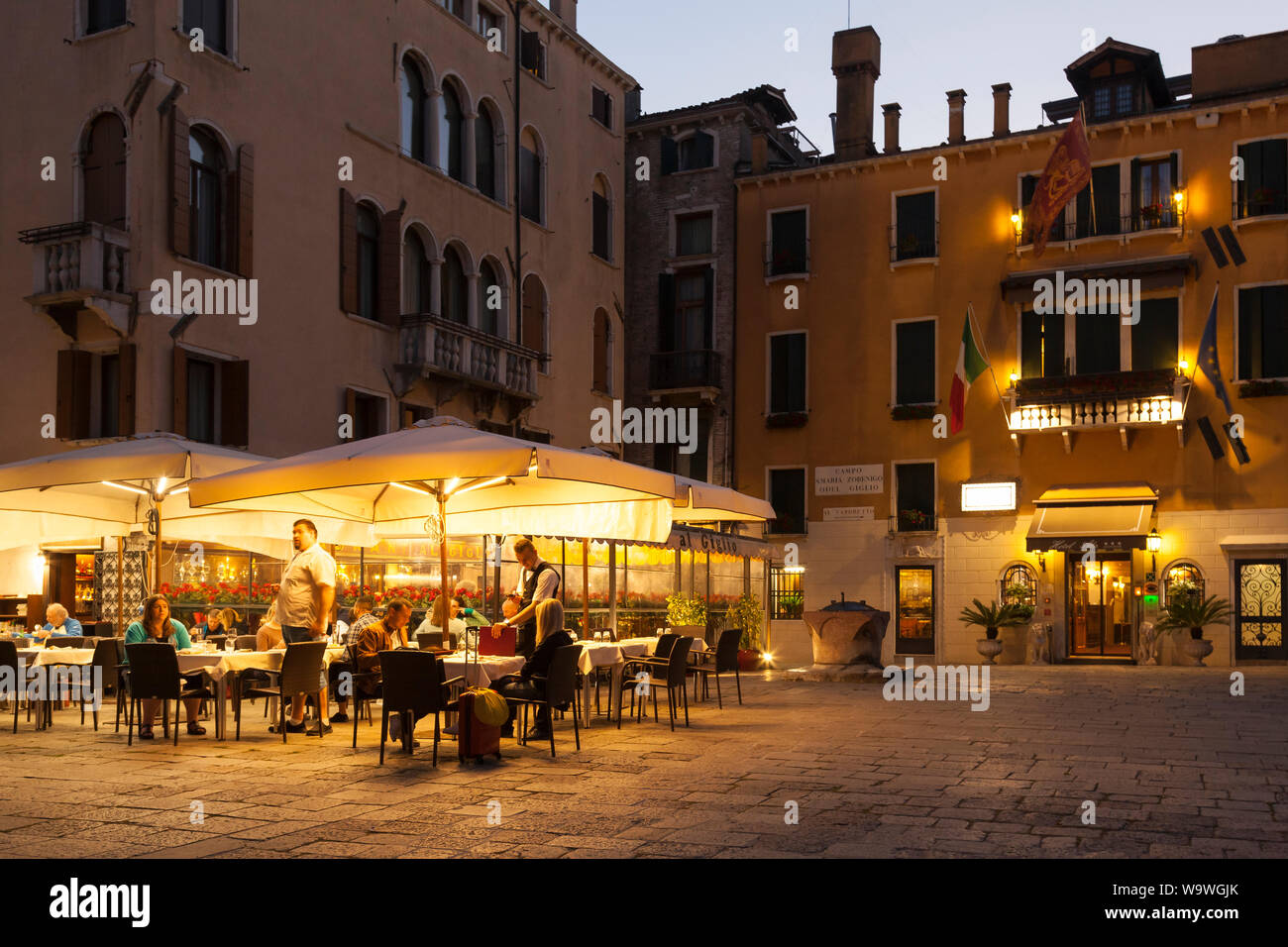 I turisti di mangiare al ristorante al Giglio di notte nel Campo Santa Maria Zobenigo o del Giglio, San Marco, Venezia, Veneto, Italia Foto Stock