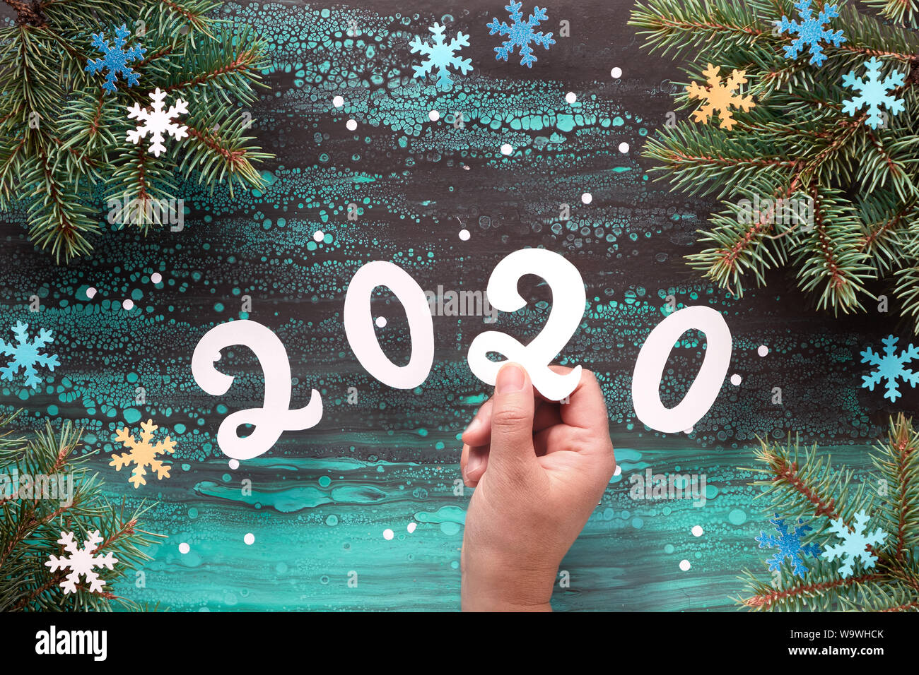 Carta di Natale sfondo in verde, blu e bianco, vista dall'alto sulla cornice rossa e numero 2020 su abstract sfondo inverno con ramoscelli di abete e fiocchi di neve Foto Stock