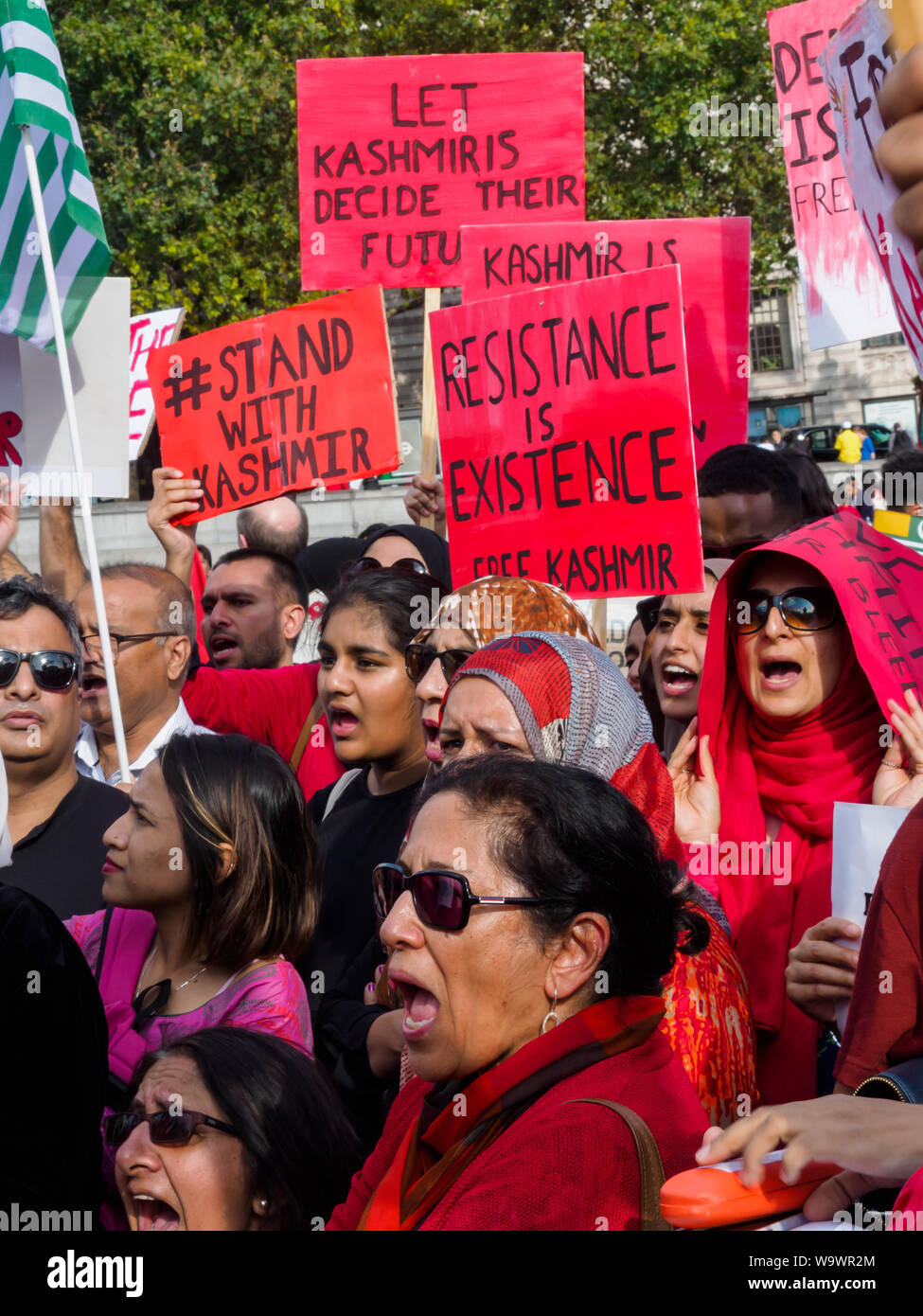 Londra, Regno Unito. Il 15 agosto 2019. Persone indossano rosso per il Kashmir alla protesta in Trafalgar Square sulla Indian Independence Day condeming gli arresti e le violazioni dei diritti umani nella regione del Kashmir e Modi la revoca dell'articolo 370 della Costituzione indiana. Vogliono che i diritti del popolo del Kashmir e rispettate le risoluzioni delle Nazioni Unite implementato e appello per la libertà per il Kashmir che è stata occupata per molti anni da oltre 700.000 truppe indiane. Ci sono state riscaldate argomenti tra i manifestanti che hanno sostenuto il Pakistan e Pakistan sventolate le bandiere e gli organizzatori della manifestazione e la protesta è suddiviso in due gruppi. P Foto Stock