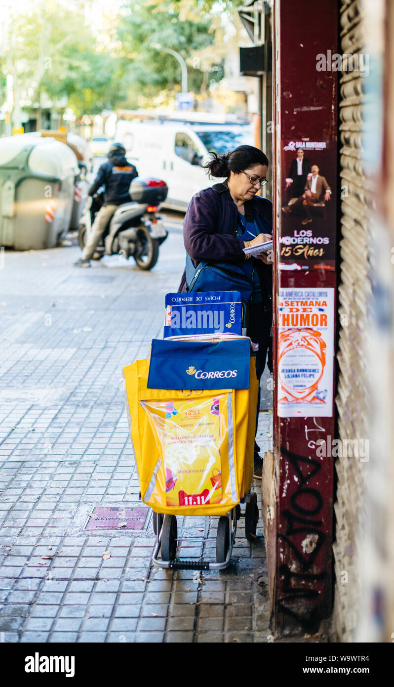 Barcellona, Spagna - 14 Nov 2017: Mailman portalettere donna con Correos carrello la consegna di posta e pacchi su strada Foto Stock