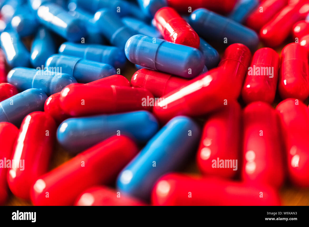 Dettaglio di una manciata di miste di rosso e blu pillole. Foto Stock